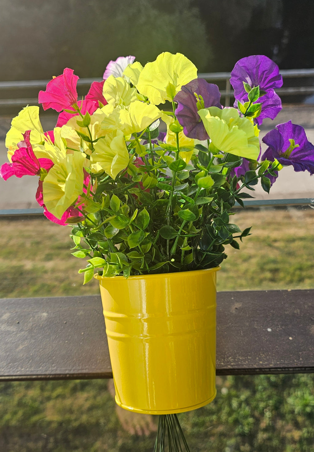 Gelber Metall-Blumentopf mit Blumen
