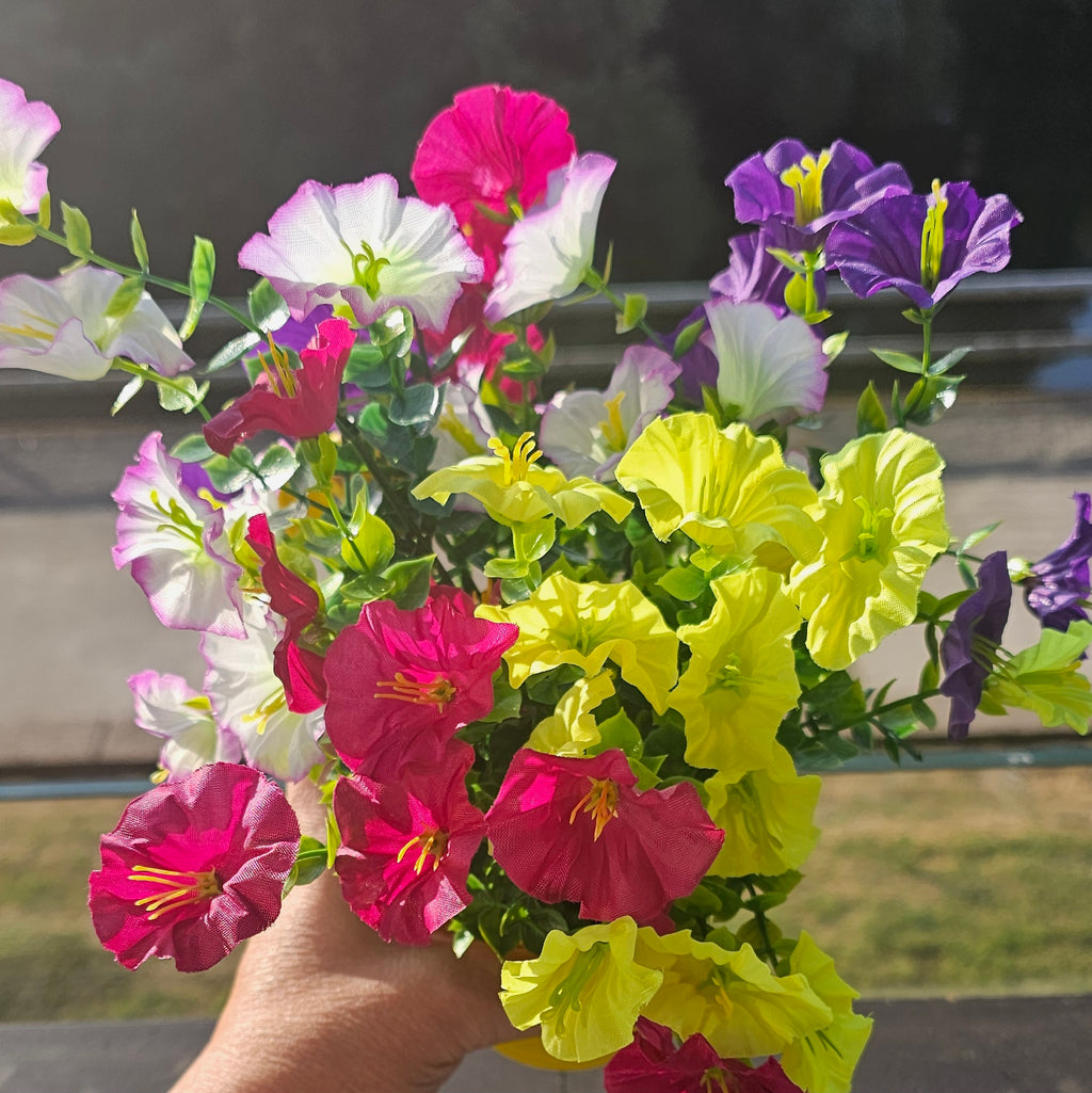 Gelber Metall-Blumentopf mit Blumen